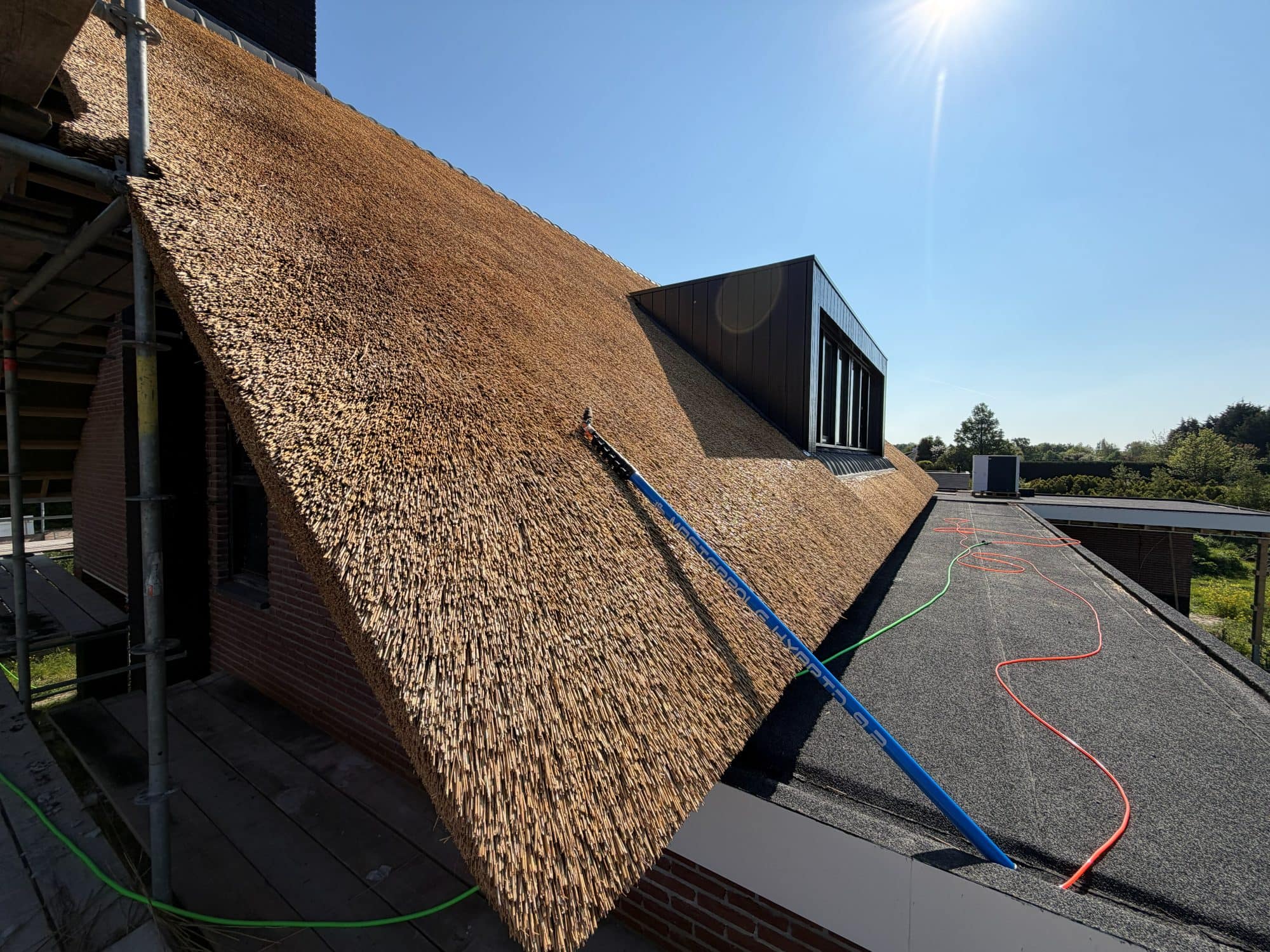 Behandeling van het rieten dak rond de dakkapel