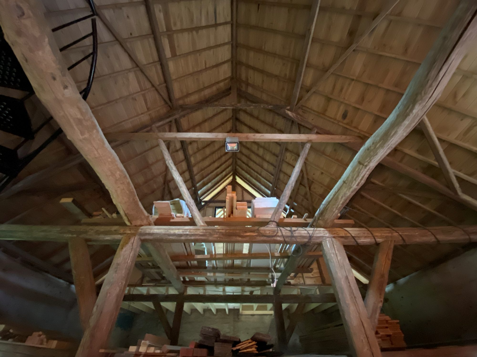Houten kapconstructie met dakbeschot en balken, gezien vanaf binnen